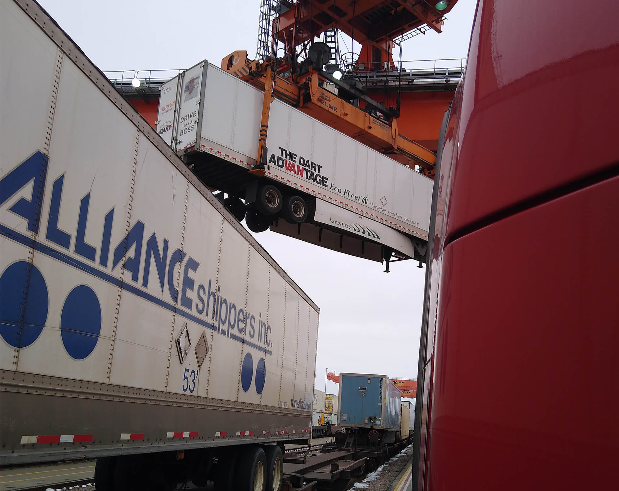 a shipping yard crane moving a dart trailer