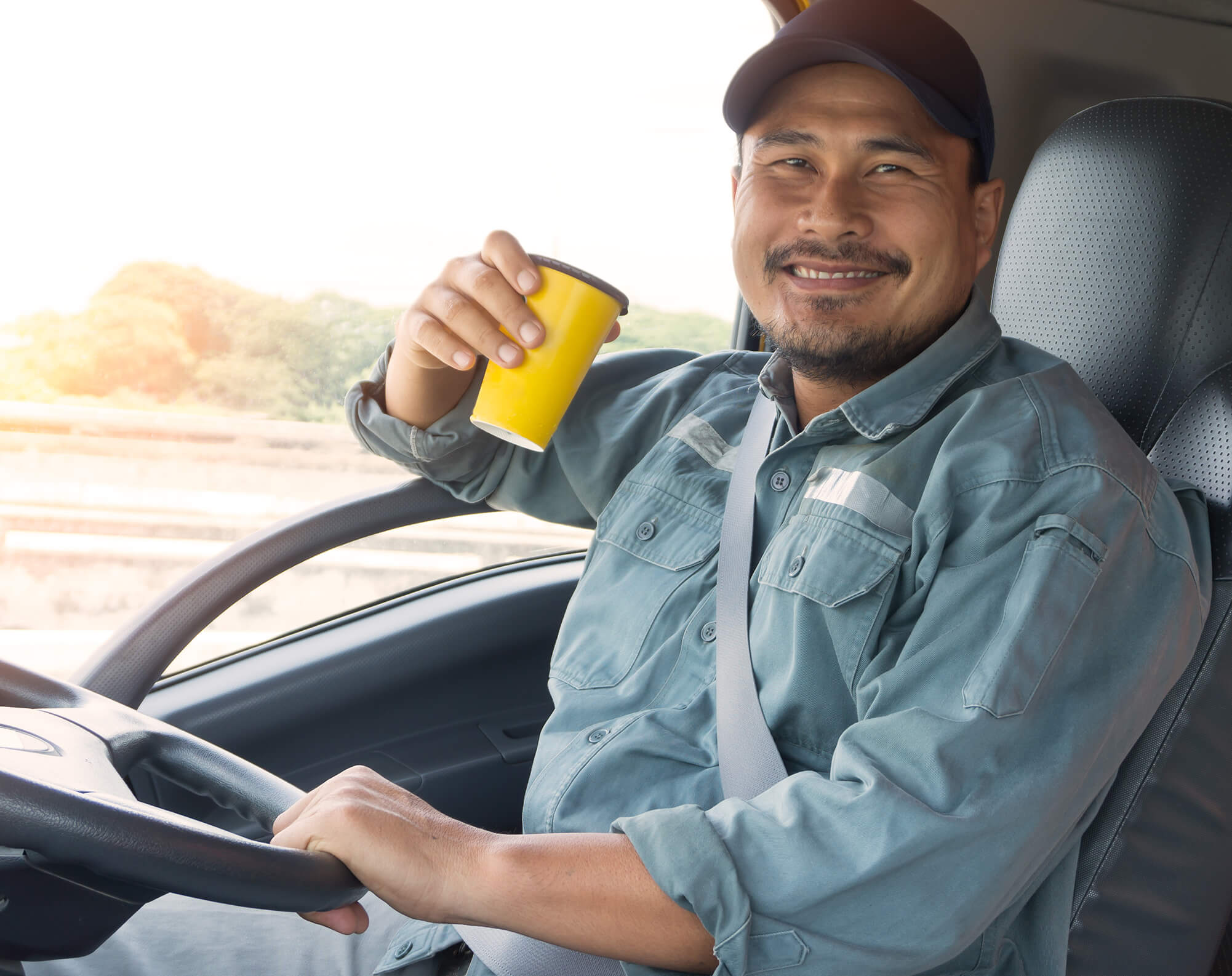a man driving a truck drinking coffee
