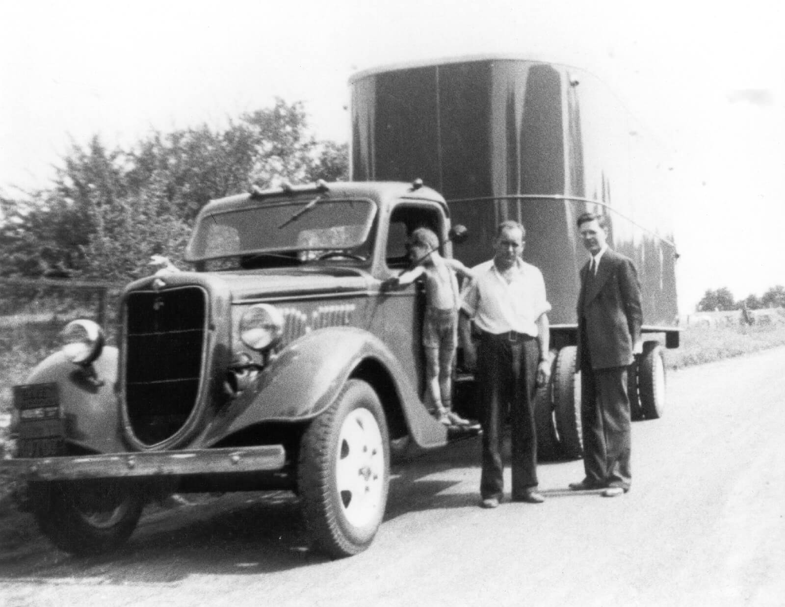Vintage photo of three men with an old Dart truck
