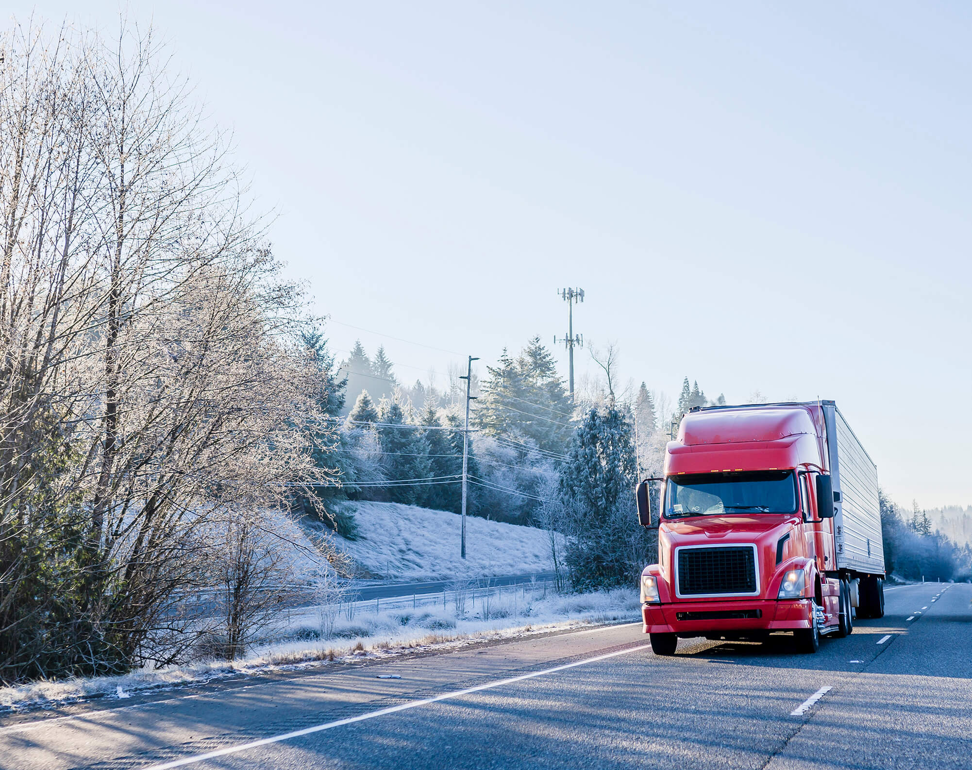 a semi truck driving down the highway in winter